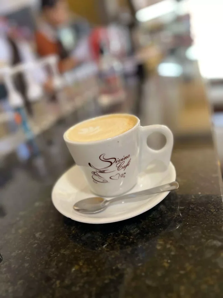 Xicara de cafe do Divino Cafe sobre o balcao