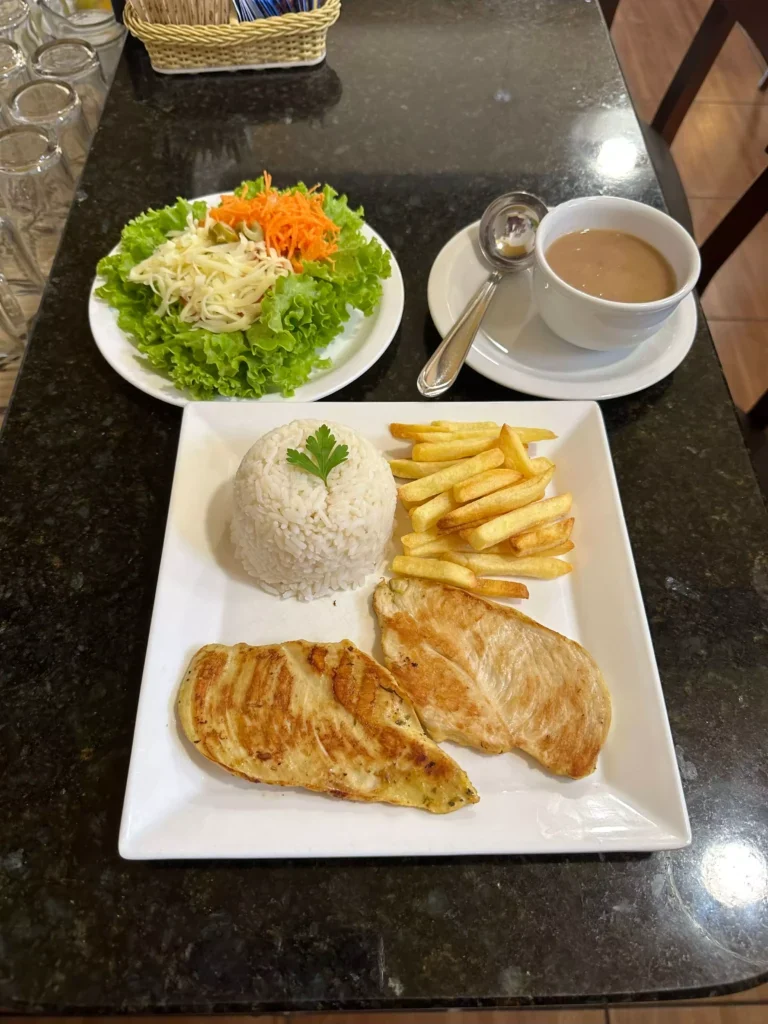 Prato de refeicao com arroz, frango, batatas e salada